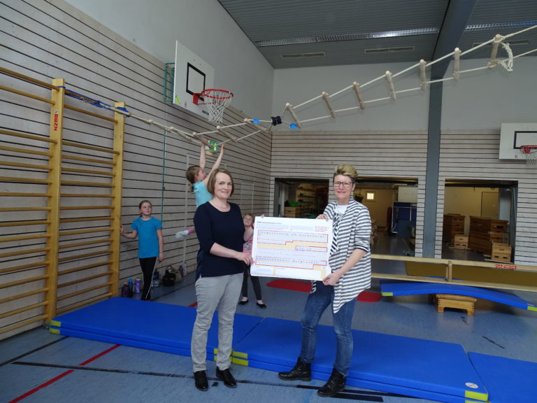 Antje Wiedmer vom Gewerbeverein Burgrieden-Achstetten übergibt die Spende an Annemone Hoffmann vom Förderverein der Grundschule Achstetten